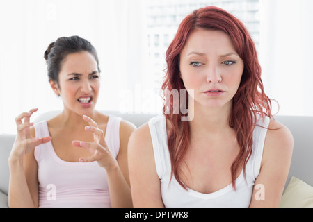 Angry female friends having an argument dans le salon Banque D'Images