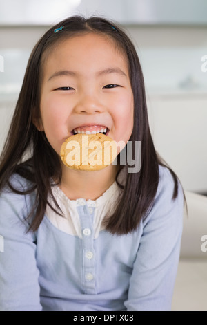 Portrait of a smiling young girl enjoying cookies Banque D'Images