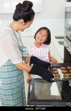 Girl aider sa mère préparer des cookies dans la cuisine Banque D'Images