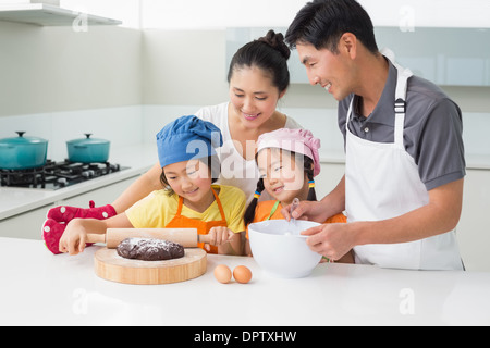 Famille heureuse de préparer quatre cookies dans la cuisine Banque D'Images