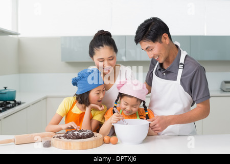 Famille heureuse de préparer quatre cookies dans la cuisine Banque D'Images