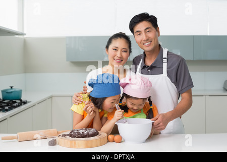 Famille de quatre, la préparation de cookies dans la cuisine Banque D'Images