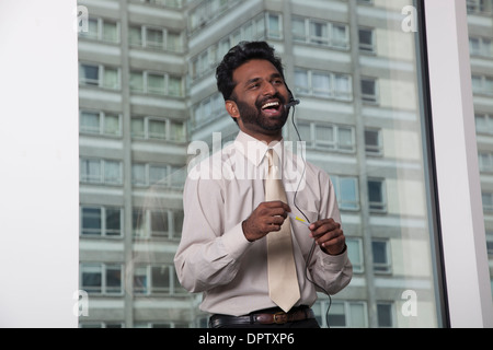 Smiling Indian businessman wearing telephone headset Banque D'Images