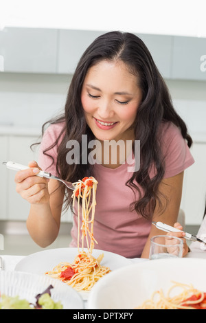 Happy young woman enjoying déjeuner spaghetti Banque D'Images