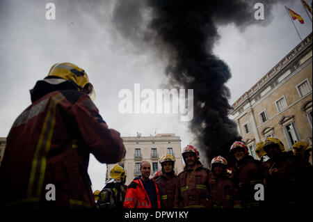 Barcelone, Espagne. 16 janvier, 2014. Une énorme colonne de fumée s'élevant du feu devant le gouvernement catalan au cours de la manifestation des pompiers à Barcelone . Pompiers Catalans (bombardiers de la Generalitat de Catalunya) ont organisé une manifestation à Barcelone contre les coupures du gouvernement catalan en raison de la crise financière qui affecte la Catalogne. Selon les pompiers compressions touchent non seulement les salaires, mais aussi des équipements nécessaires pour agir en cas d'urgence. La protestation a été tenue en face de gouvernement catalan et le Parlement Catalan. Crédit : Jordi Boixareu/Alamy Live News Banque D'Images
