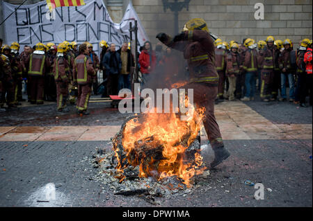 Barcelone, Espagne. 16 janvier, 2014. Saute par-dessus un feu de pompier pendant la manifestation qui a eu lieu à Barcelone. Pompiers Catalans (bombardiers de la Generalitat de Catalunya) ont organisé une manifestation à Barcelone contre les coupures du gouvernement catalan en raison de la crise financière qui affecte la Catalogne. Selon les pompiers compressions touchent non seulement les salaires, mais aussi des équipements nécessaires pour agir en cas d'urgence. La protestation a été tenue en face de gouvernement catalan et le Parlement Catalan. Crédit : Jordi Boixareu/Alamy Live News Banque D'Images