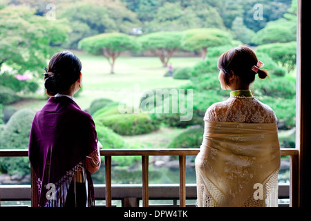 Vue arrière de deux femmes surplombant le grand parc vert au Japon. Banque D'Images