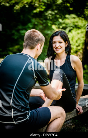 Jeune homme massage donne à son ami des veaux après l'entraînement sportif Banque D'Images