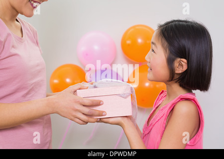 Woman giving gift box pour une petite fille à une fête Banque D'Images