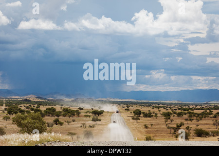 La poussière provenant du véhicule et qui s'approche et une tempête de pluie marquent le paysage du Damaraland, en Namibie Banque D'Images