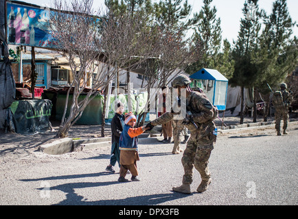 Les soldats de l'Armée US Messages d'échanges avec un enfant au cours d'une patrouille autour du consulat des Etats-Unis, le 5 janvier 2014 à Herat, Afghanistan, Janvier 5, 2014. Banque D'Images