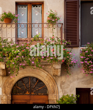 Fleurs sur balcon sur porte d'accueil en Piezna, Toscane, Italie Banque D'Images