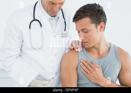 Médecin homme l'injection d'un bras de patients Banque D'Images