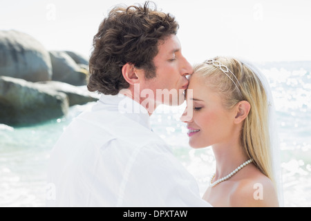 Groom kissing sa jolie nouvelle femme sur le front Banque D'Images