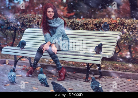 Jeune femme dans le parc assis sur un banc. Banque D'Images