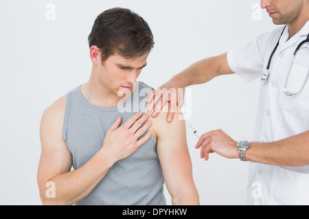 L'injection d'un homme médecin les jeunes gens arm Banque D'Images