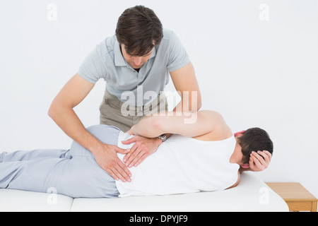 Physiotherapist examining Male mans retour Banque D'Images