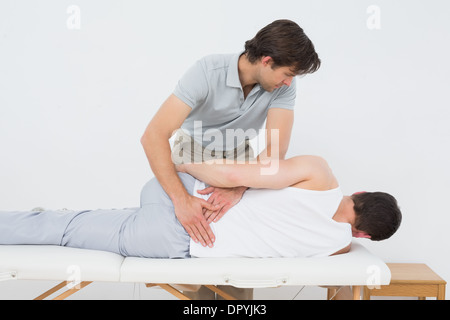 Physiotherapist examining Male mans retour Banque D'Images