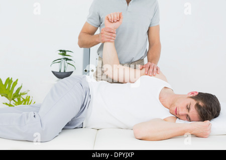 Un jeune mâle physiotherapist examining mans hand Banque D'Images
