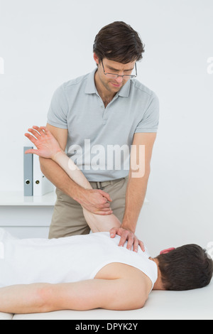 Un jeune mâle physiotherapist examining mans hand Banque D'Images