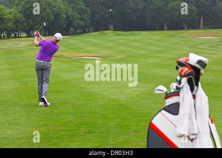 Un golfeur jouant un milieu fairway fer à repasser dans le vert sur un pair 4 trou, série de 3. L'accent est mis sur le golfeur. Banque D'Images