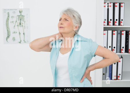 Hauts femme souffrant de douleur au cou in medical office Banque D'Images