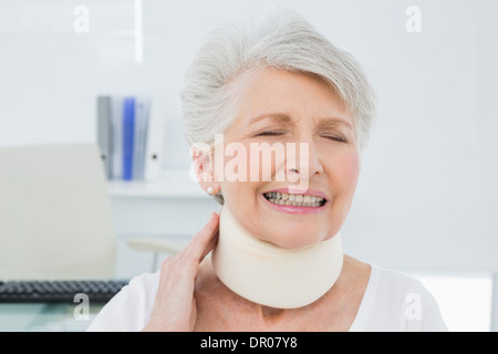 Senior woman wearing collier cervical avec les yeux fermé Banque D'Images
