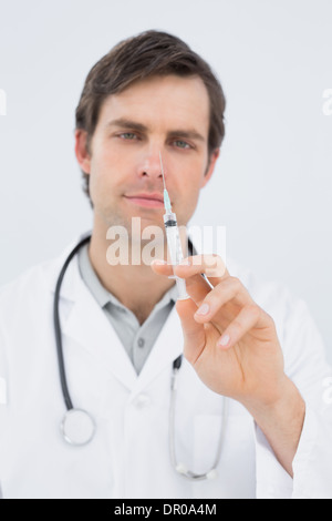 Portrait of a handsome male doctor holding an injection Banque D'Images