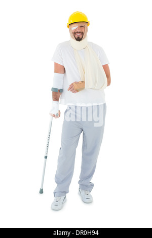 Jeune homme en casque avec fracture de la main et béquille Banque D'Images