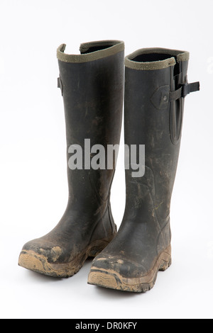 Bottes boueuses sur un fond blanc. Banque D'Images