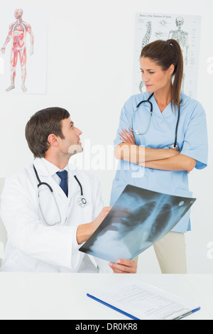 Médecin de sexe masculin et féminin surgeon examining x-ray Banque D'Images