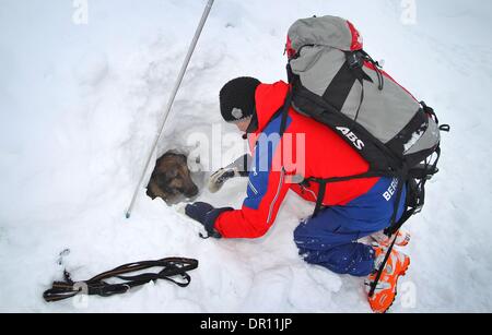 Garmisch-Partenkirchen, Allemagne. 17 Jan, 2014. Avalanch entraîneur de chien Franz Schreiber s'agenouille à côté de rescue dog Aico comme il creuse des survivants lors d'un exercice d'entraînement dans les Alpes, près de Garmisch-Partenkirchen, Allemagne, 17 janvier 2014. Dresseurs de chiens de sauvetage en montagne sont la formation de leurs chiens de recherche de victimes d'avalanche pour une semaine. Photo : Karl Josef OPIM/dpa/Alamy Live News Banque D'Images