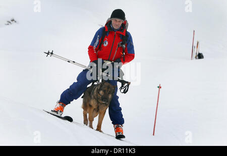 Garmisch-Partenkirchen, Allemagne. 17 Jan, 2014. Avalanch entraîneur de chien Franz Schreiber skies sur la pente avec rescue dog Aico entre ses jambes lors d'un exercice d'entraînement dans les Alpes, près de Garmisch-Partenkirchen, Allemagne, 17 janvier 2014. Dresseurs de chiens de sauvetage en montagne sont la formation de leurs chiens de recherche de victimes d'avalanche pour une semaine. Photo : Karl Josef OPIM/dpa/Alamy Live News Banque D'Images