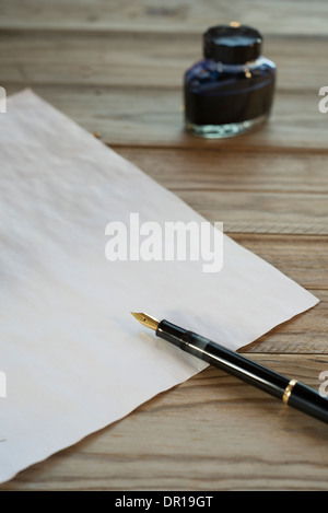 Stylo plume, encre et feuille de papier sur une table en bois Banque D'Images