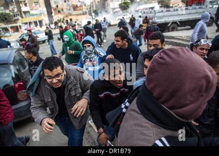 Le Caire, Égypte. 17 Jan, 2014. Des manifestants anti-militaires s'échapper des gaz lacrymogènes tirés par la police au Caire, Egypte, le 17 janvier 2014. Au moins une personnes a été tué vendredi en Egypte au cours d'affrontements entre la police et les partisans du Président islamiste déchu Mohamed Morsi, site web officiel actualités Al-Ahram a rapporté. Credit : Amru Salahuddien/Xinhua/Alamy Live News Banque D'Images