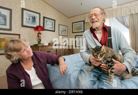 25 novembre 2008, Escondido, California, USA 79 ans JACK CALKINS est assis sur son lit comme il est titulaire d'Mama, un de ses deux chats. Il les nourrit avec des aliments livrés par Animeals, un programme de la Helen Woodward Animal Center. À gauche s'DIANNE WALTER, de repas sur roues, une organisation qui lui apporte quotidiennement de la nourriture Credit : photo par Charlie Neuman, San Diego Union-Tribune/Zuma Press. copyr Banque D'Images