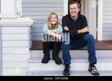 Caucasian father and daughter smiling on steps Banque D'Images