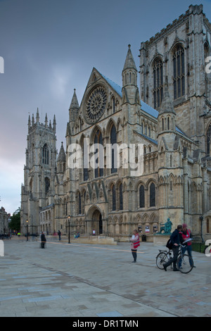 Soir dans le tranquille et pittoresque piazza - les gens par l'entrée sud et tour de la cathédrale magnifique contre ciel noir - York, North Yorkshire, Angleterre, Royaume-Uni. Banque D'Images