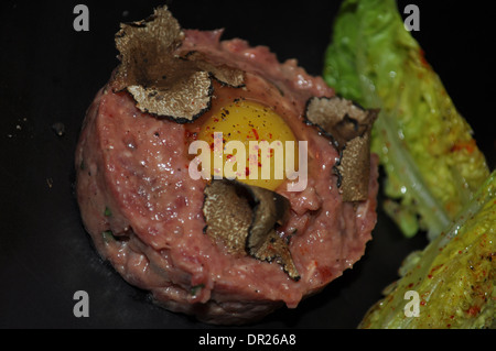 Steak tartare de copeaux de truffe servi dans un restaurant étoilé Michelin à Londres servi sur ardoise noire Banque D'Images