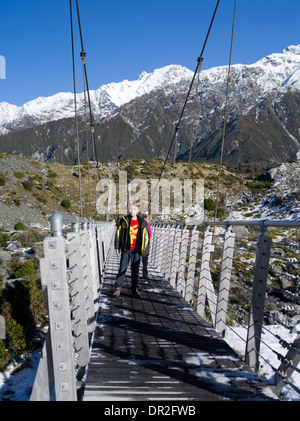 Un garçon et une fille marcher sur un pont suspendu comme ils clochard vers la vallée ; Hooker Aoraki/mont. Cook, nouveau Zeala Banque D'Images