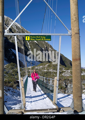 Une femme de clochards à travers le Hooker Bluff Suspension Bridge sur son chemin à la Hooker Valley ; parc Aoraki/Mt. Cook National Park, New Zea Banque D'Images