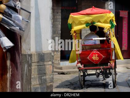 Zhengzhou. 18 janvier, 2014. Photo prise le 25 avril 2013 montre un tricycle touristique passant la voie d'une ville ancienne dans le comté Feixi de la Chine de l'est la province d'Anhui. Le caractère chinois "Fu", qui signifie 'bonne chance', est commune partout à travers la Chine pendant la fête du printemps. Il est populaire pour son sens propice, peut aussi être comprise comme "bonheur", que le peuple chinois croient leur bénédiction dans la nouvelle année. © Wang Song/Xinhua/Alamy Live News Banque D'Images