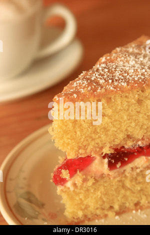 Café et gâteau cappuccino avec une tranche de confiture et de crème gâteau rempli Banque D'Images