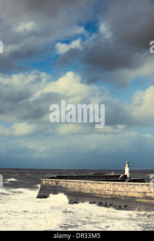 Vagues se briser contre le mur avec la mer phare à Whitehaven, Angleterre, RU Banque D'Images