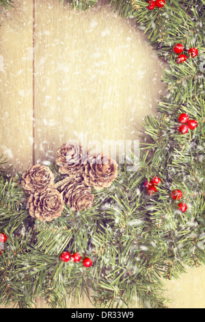 Guirlande de Noël accrochée à la porte en bois avec des chutes de neige Banque D'Images
