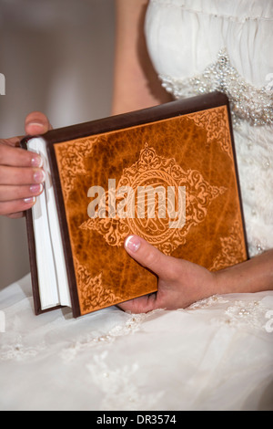 Une bride holding un exemplaire du Coran au cours d'une cérémonie de mariage iranien. Banque D'Images