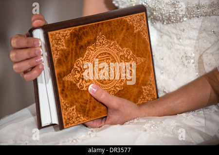 Une bride holding un exemplaire du Coran au cours d'une cérémonie de mariage iranien. Banque D'Images