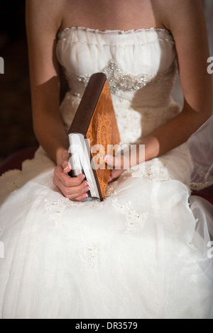 Une bride holding un exemplaire du Coran au cours d'une cérémonie de mariage iranien. Banque D'Images