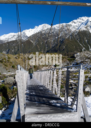 Un homme asiatique marche à travers un pont suspendu sur son chemin jusqu'à la prostituée Valley Track, Aoraki/mont. Cook. Banque D'Images