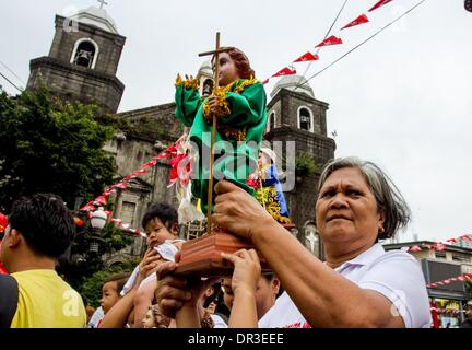 Manille, Philippines. 18 janvier, 2014. La région métropolitaine de Manille, Philippines - 18 janvier, 2014 : un dévot exerçant son droit de l'Enfant Jésus Lakbayaw festival, ÃƒÂ¢ ? ?LakbayawÃƒÂ¢ ?Â du Tagalog mots, 'Lakbay" (voyage) et "ayaw" (danse) dans la zone urbaine de Tondo, Manille, qui unit presque toutes les organisations, les écoles, les groupes communautaires et les gens de Tondo dans le cadre de leur dévotion à Santo Nino.Les Philippines sont le seul pays catholique en Asie du sud-est autour de 93 pour cent avec l'exercice de la foi. © Herman R. Lumanog/NurPhoto ZUMAPRESS.com/Alamy/Live News Banque D'Images